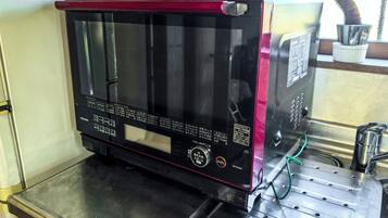 Een Toshiba magnetron met een digitaal display, geplaatst op een metalen oppervlak.