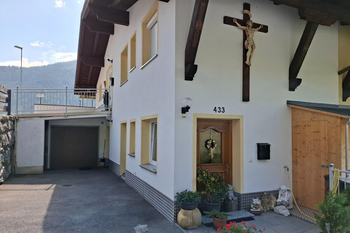 A building with a wooden cross, a door with a wreath, and the number 433.