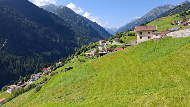A mountainous village with houses on a hillside, surrounded by forested mountains. - Cozy Apartment With a Beautiful View (Kappl)