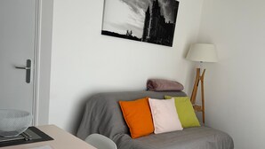 A modern bedroom with a bed, bedside table, chair, lamp, and a painting on the wall. - Le Hameau du Peu - Happy Cottage with Shared Pool (Châteauvieux)