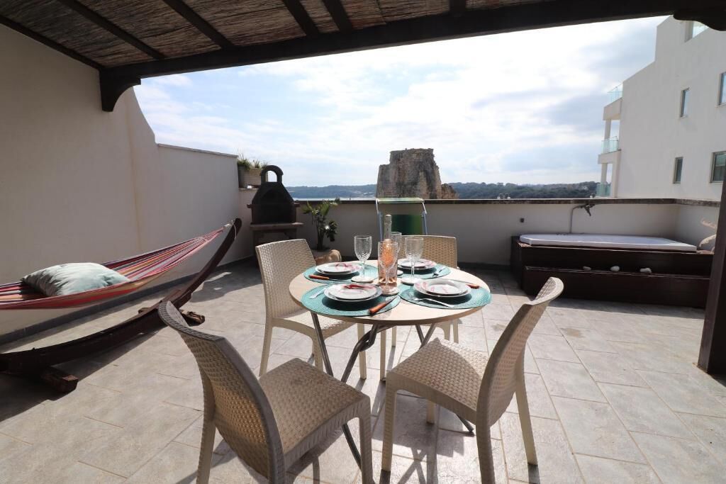 Une terrasse sur le toit, avec une table à manger pour deux, un hamac et une vue sur le paysage urbain.