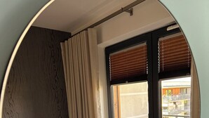 A bedroom with a bed, curtains, a window, and a view of an outdoor balcony. - OLIMPIC Apartament Suwałki AirCon Garage Self-Check In/Out (Suwałki)