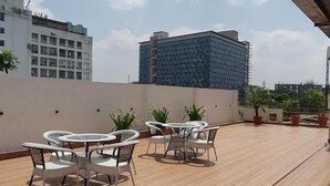 A rooftop terrace with outdoor seating and a view of surrounding buildings. - Joey's hostel Jaipur (Jaipur)