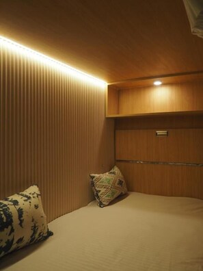 A room with a bed, a bedside table, and a wall-mounted shelf. - Joey's hostel Jaipur (Jaipur)