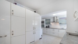Una cocina moderna con armarios blancos, electrodomésticos de acero inoxidable y encimera de granito.