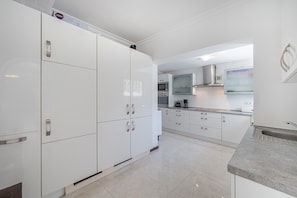 Una cocina moderna con armarios blancos, electrodomésticos de acero inoxidable y encimera de granito.