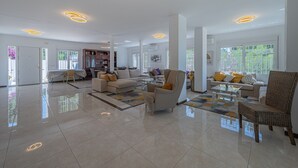 Un salón amplio con un sofá grande, una mesa de centro y un sillón de mimbre.