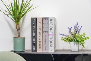 A bookshelf with books and two potted plants. - Refined vacation home located a few steps from Ponte Milvio (Roma)