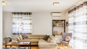 A living room with a sectional sofa, a chair, a coffee table, and a bookshelf. - Holiday Home Fulia with pool (Galižana)