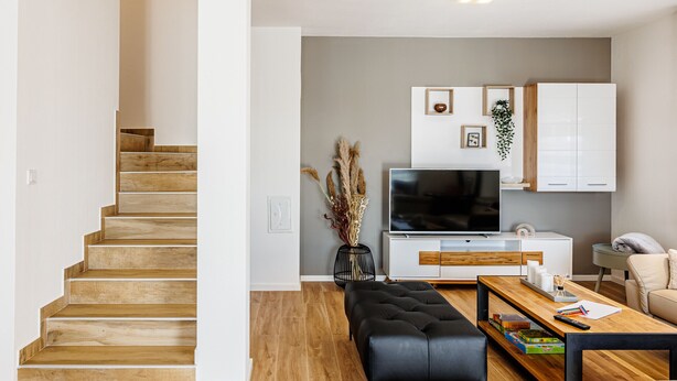 A modern living room with a wooden staircase, a flat-screen TV, a coffee table, and a sofa. - Holiday Home Fulia with pool (Galižana)