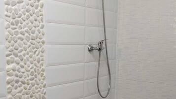 Een douche, een haardroger, handdoeken, toiletpapier