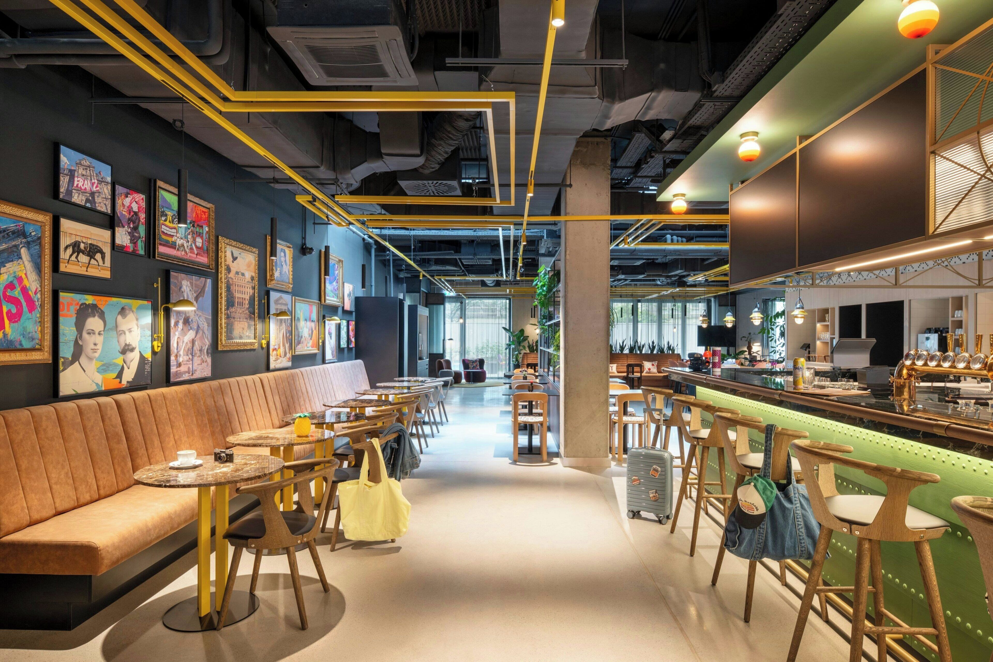 A modern interior with a bar area, seating, and artwork on the walls.