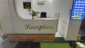 Un mostrador de recepción con un letrero que indica los horarios de registro de entrada y salida.