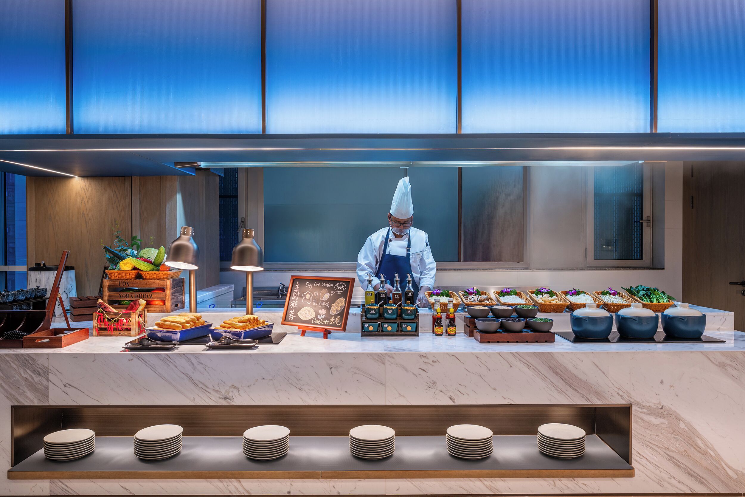 A buffet setup with a chef, various food items, and condiments.