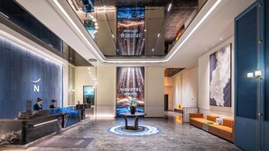A modern hotel lobby with a reception desk, seating area, and a large digital display. - Novotel Chengdu Chunxi Road (Chengdu)