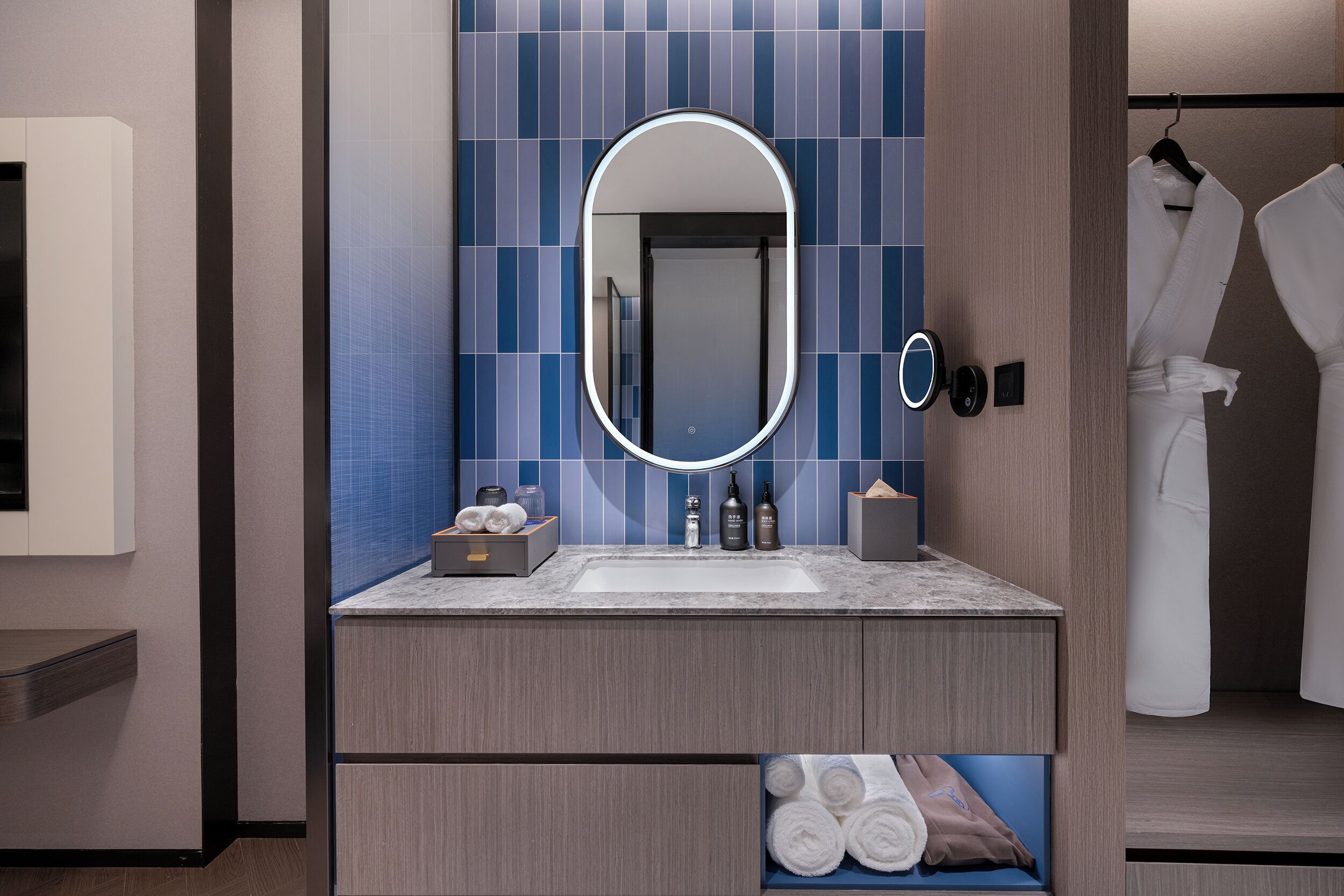 A modern bathroom with a large mirror, a sink, and a towel rack.