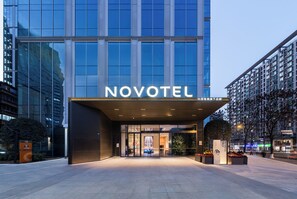 A modern hotel entrance with a large glass facade, a prominent 'NOVOTEL' sign, and a well-lit entrance area. - Novotel Chengdu Chunxi Road (Chengdu)