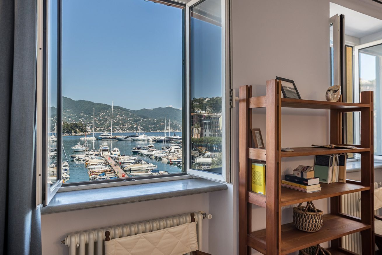 Ein Zimmer mit Blick auf eine Marina, einem Holzbücherregal und einer Heizung.