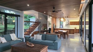 A modern living space with a staircase, a dining area, and a kitchen. - Villa Maxwell (Tabanan)