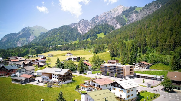 A residential area with houses, a road, and mountains in the background.