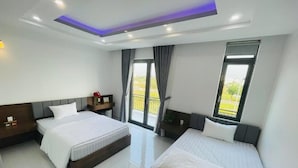 A hotel room with two beds, a balcony, and a modern design. - Tram Anh 2 Hotel Dong Nai - BAY LUXURY (Nhơn Trạch)