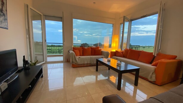 A spacious living room with a flat-screen TV, a coffee table, and a sofa set. - Apartment 'Olyvia' with Sea View, Wi-Fi and Air Conditioning (Plaka Litochorou)