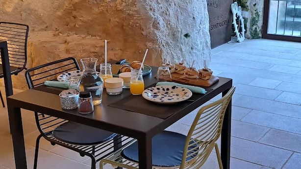 A table set with breakfast items, including pastries, a fruit bowl, and drinks. - Masseria Torre Sant'Andrea  (Borgagne)