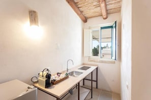 Una cocina compacta con estufa integrada, un lavamanos y un ventanal con vistas.