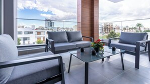 A balcony with a sofa, chairs, and a glass table. - Sunflower 1-BR Apt. & Balcony in Larnaca (Larnaca)