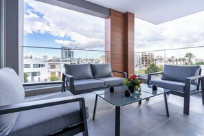 A balcony with a sofa, chairs, and a glass table. - Sunflower 1-BR Apt. & Balcony in Larnaca (Larnaca)