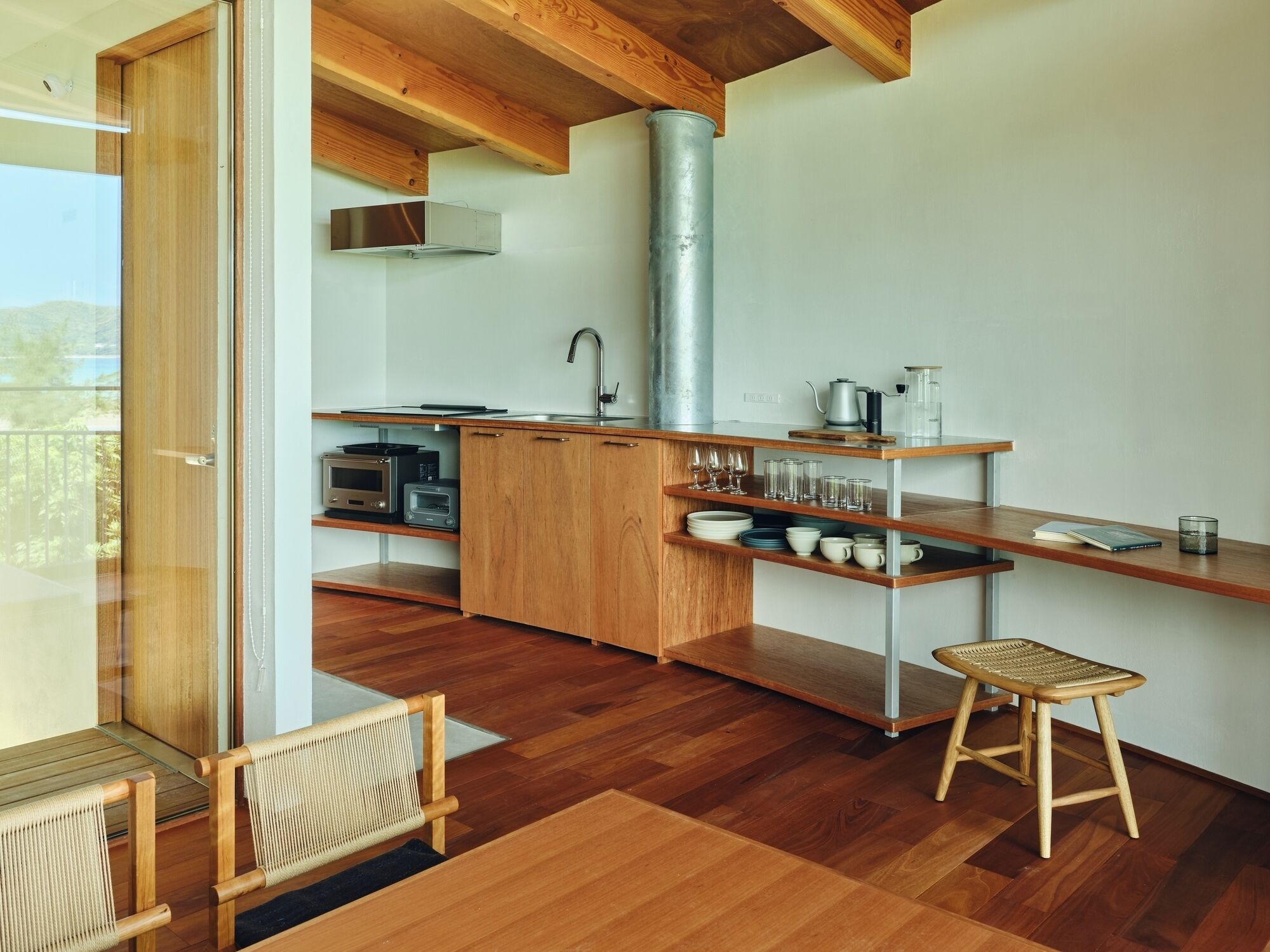 Une cuisine moderne avec des meubles en bois, un évier en acier inoxydable et un four encastré.