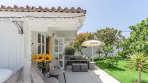 An outdoor patio with a white pergola, wicker furniture, and a dining table with chairs. - Guesthouse 'Casa Caro' with Mountain Views, Wi-Fi, and Air Conditioning (Estepona)