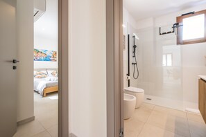 Ein modernes Badezimmer mit Duschkabine aus Glas, Toilette und Waschbecken.