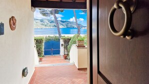 Porta de entrada para um terraço com vista para um corpo d'água e colinas.