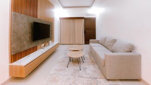 A modern living room with a flat-screen TV, a sofa, a coffee table, and a patterned rug. - Villa Morich (Jimbaran)