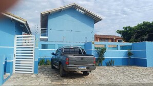 A blue building with a truck parked in front. - Comfort and fun. Beachfront. Small pets are accepted. (Itanhaém)