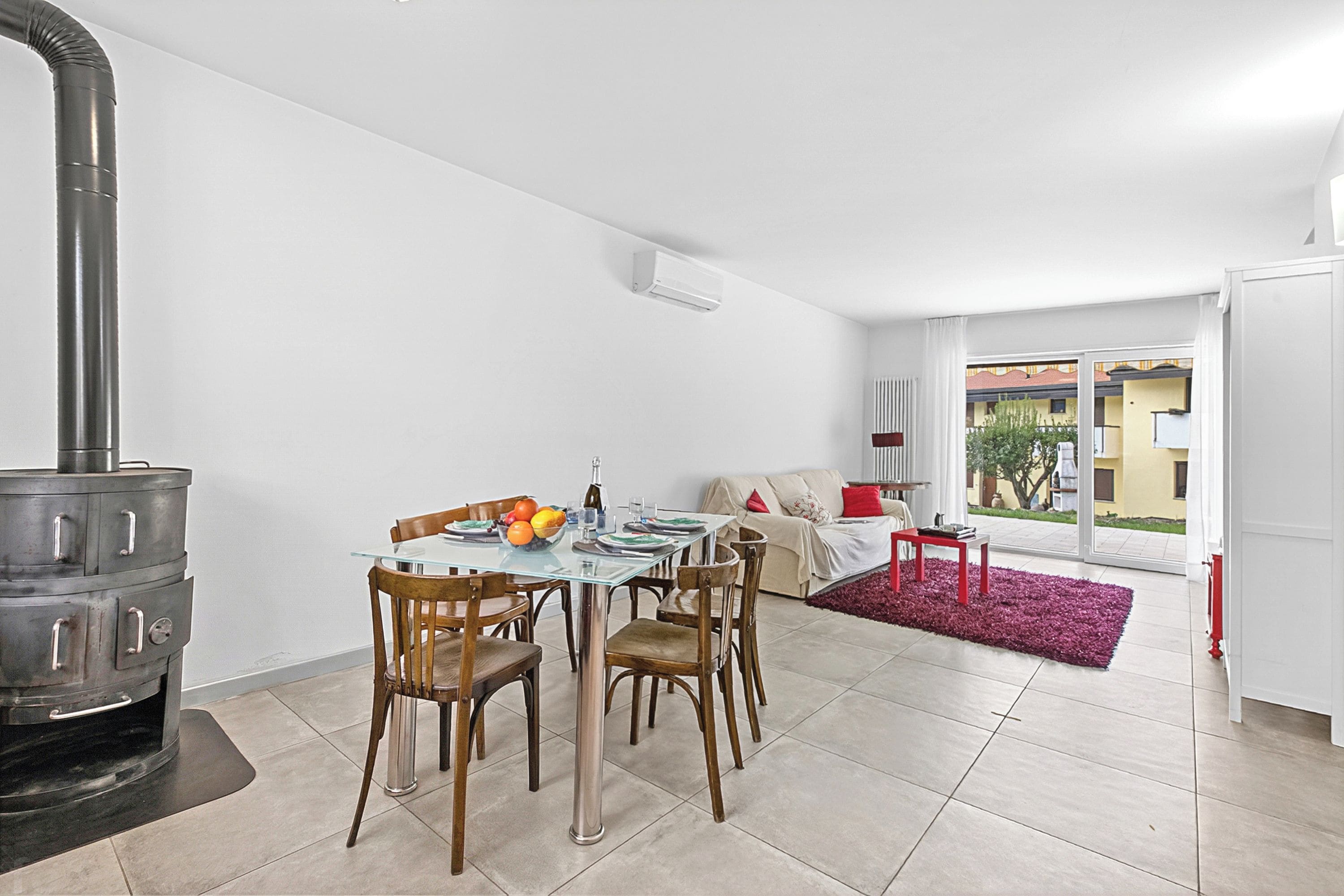 Una cocina moderna con estufa integrada, una mesa de comedor con sillas y vistas al exterior.