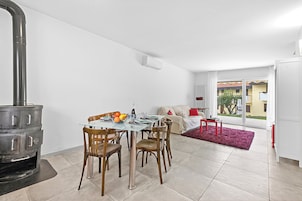 A modern kitchen with a built-in stove, a dining table with chairs, and a view of the outside.