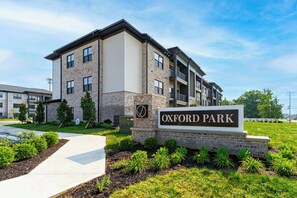 Un immeuble d’appartements à plusieurs étages, sur lequel on peut lire l’inscription « OXFORD PARK ».