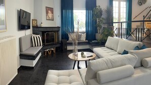 Una sala de estar con chimenea, sofás, una mesa de centro y una escalera.