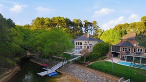 Une grande maison avec une piscine, un quai et un accès à une rivière.