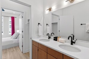 Un bagno moderno con due lavandini, uno specchio grande e un armadio a muro.