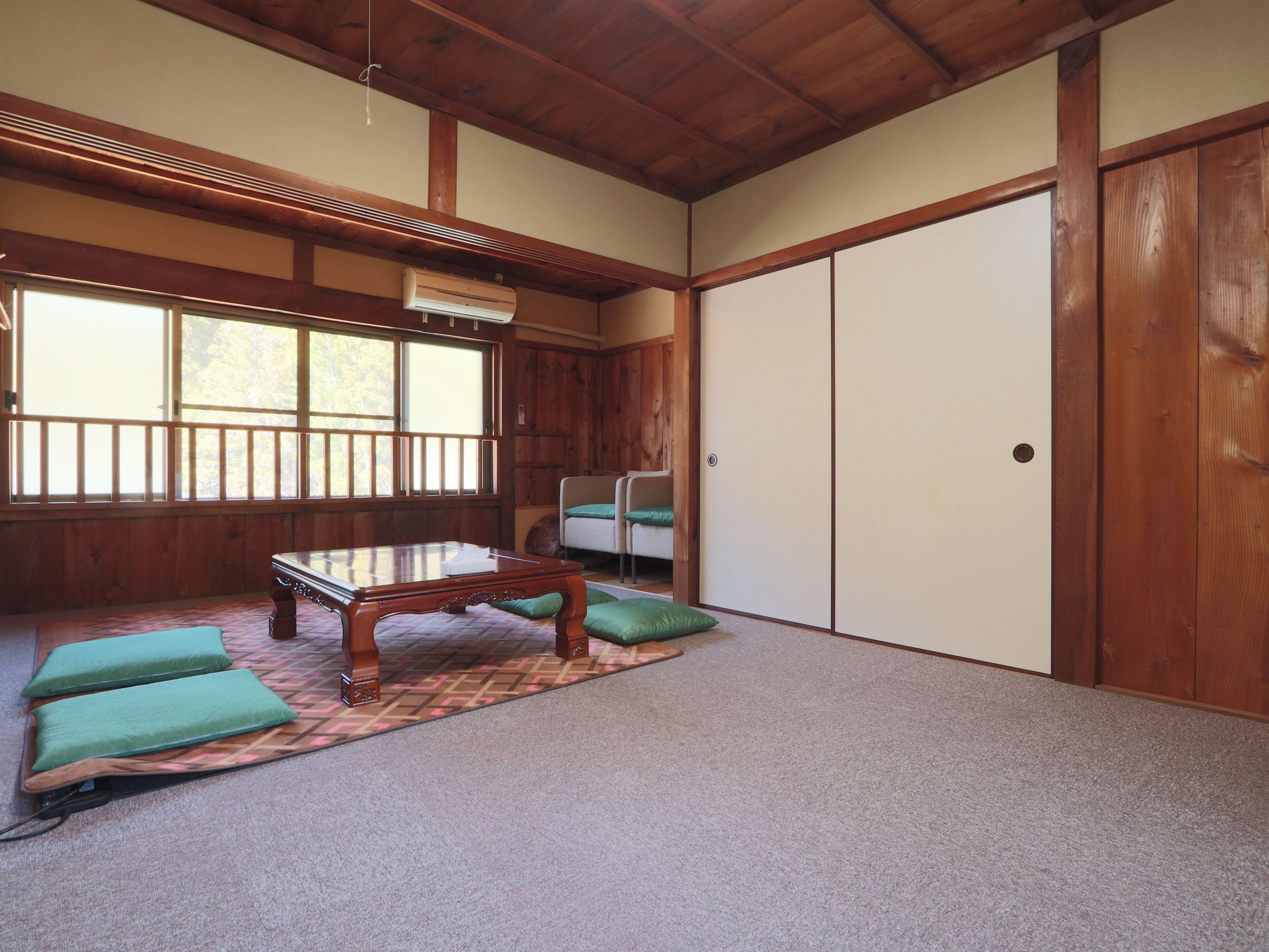 A traditional Japanese room with tatami flooring, a low wooden table, and sliding doors.
