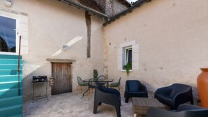 A courtyard with a barbecue grill, outdoor seating, and a staircase. - Gite de la Ferme de la Dalbeine – 25 min from Chenonceaux (Veuzain-sur-Loire)