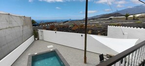 A rooftop with a swimming pool, a view of the sea, and a mountainous landscape. - Casa Con Piscina Aislada, a 5 minutos de la playa y con atardeceres mágicos (Tazacorte)