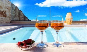 Two glasses of wine and a bowl of strawberries by a pool with a clear blue sky. - Villa Akalli | Private Pool & Hot Tub in a Restored Venetian Residence (Agia Paraskevi)