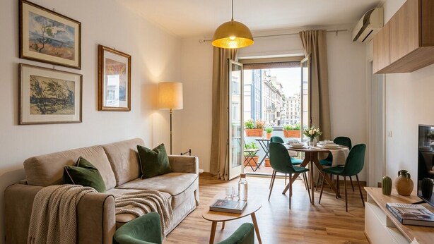 Una sala de estar con un sofá, sillones, una mesa de centro, una lámpara y obras de arte en la pared.