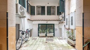 Un patio con una bicicleta, plantas en macetas y un ventilador.