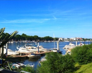 En småbåtshamn med förtöjda båtar, en klar himmel och byggnader i bakgrunden.