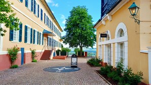 Una calle adoquinada con edificios, un árbol y un letrero de tienda.